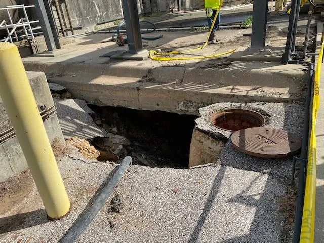 Damaged industrial concrete floor with exposed pit.