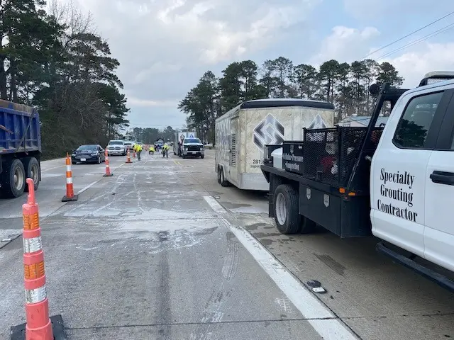 Road construction, vehicles, and workers on highway.