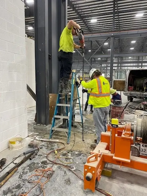 Workers installing equipment in industrial building.