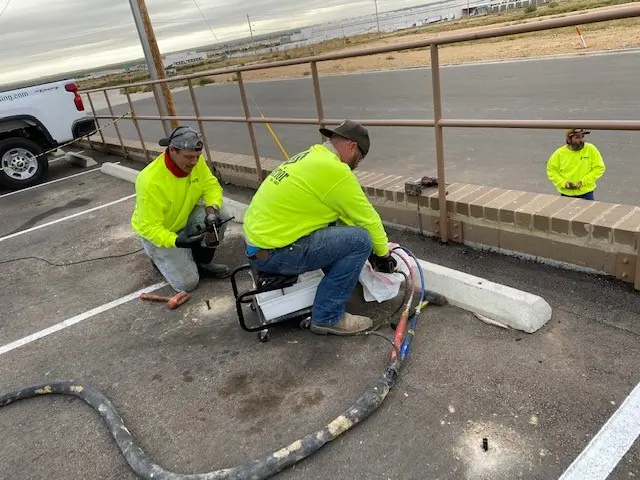 Workers in neon vests working on roadside.