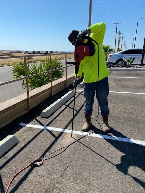 Worker using power tool on parking lot lines.